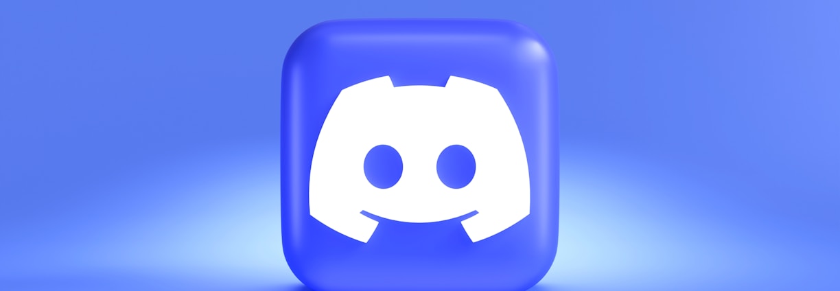 A three-dimensional blue cube featuring a white, stylized gaming controller symbol associated with a popular communication platform, set against a gradient blue background.